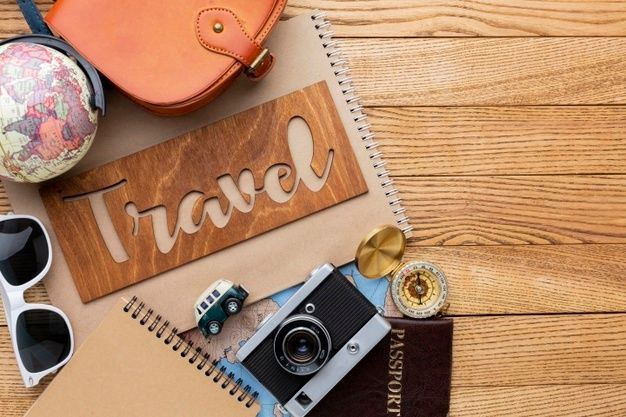 Essential Travel Items on a Rustic Wooden Background